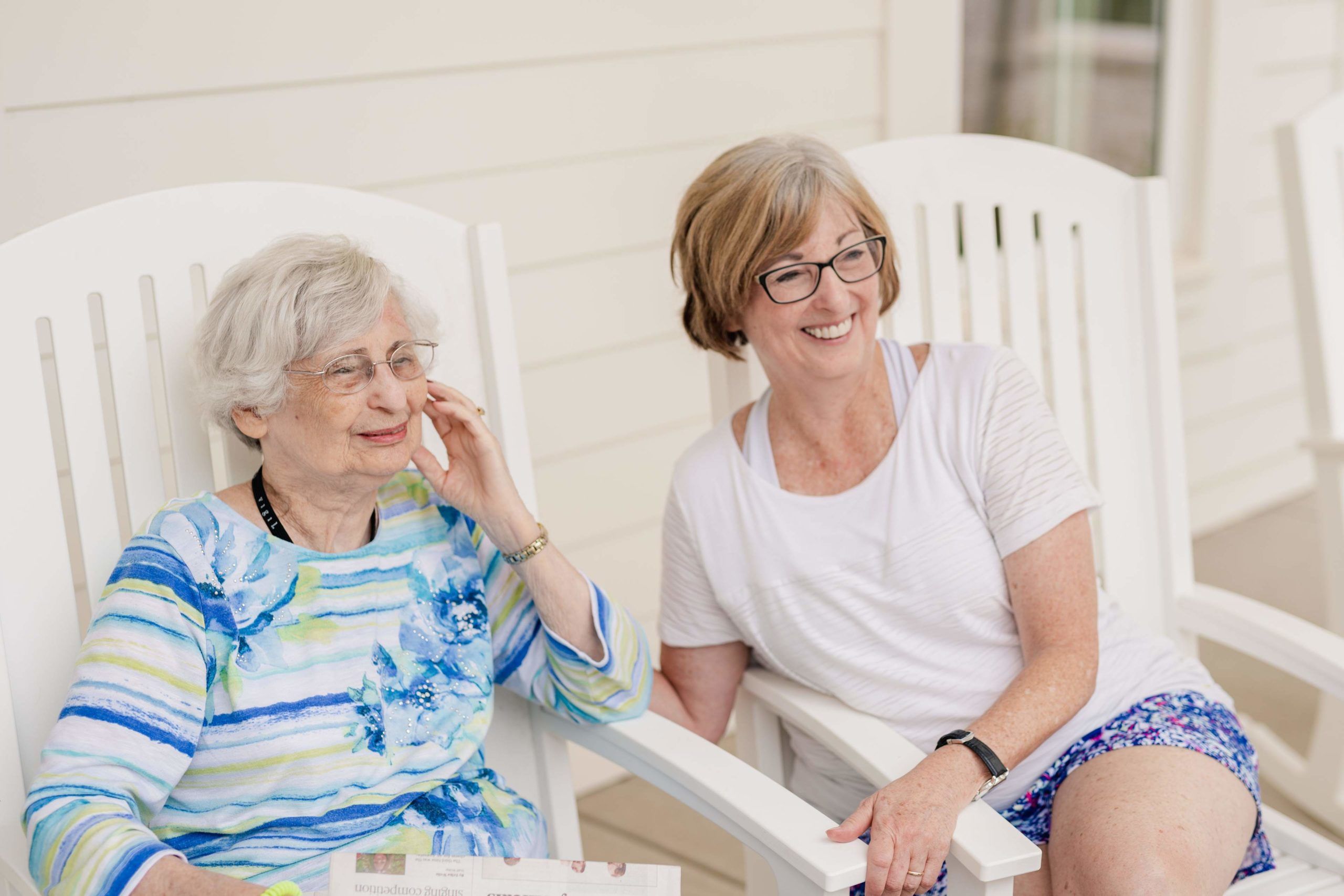 The Claiborne at Baton Rouge senior woman and daughter sitting in rocking chairs at a Claiborne community