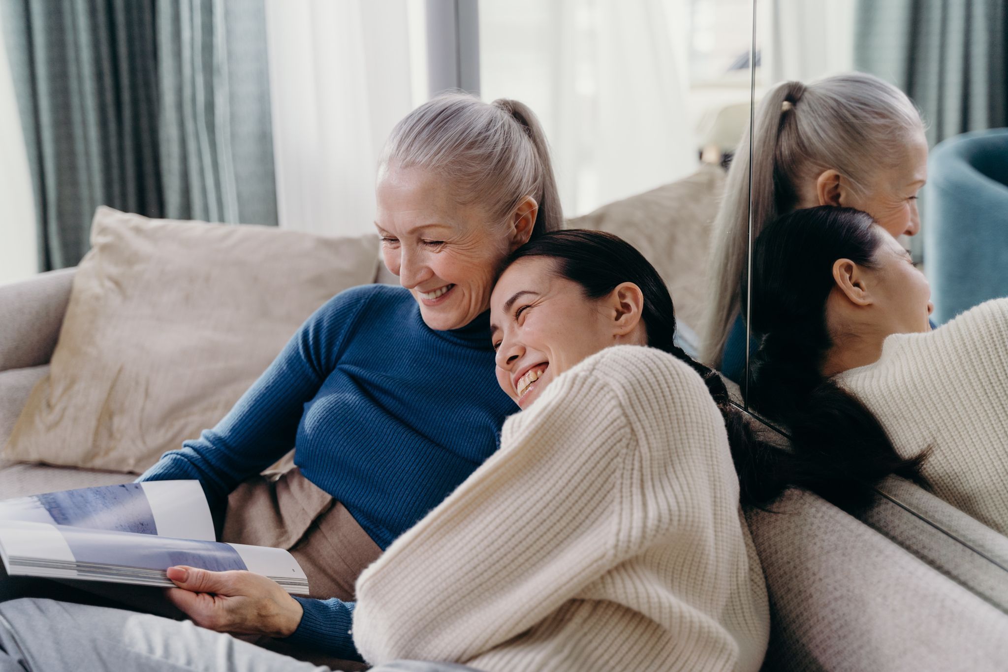 Mother daughter laughing together on a couch