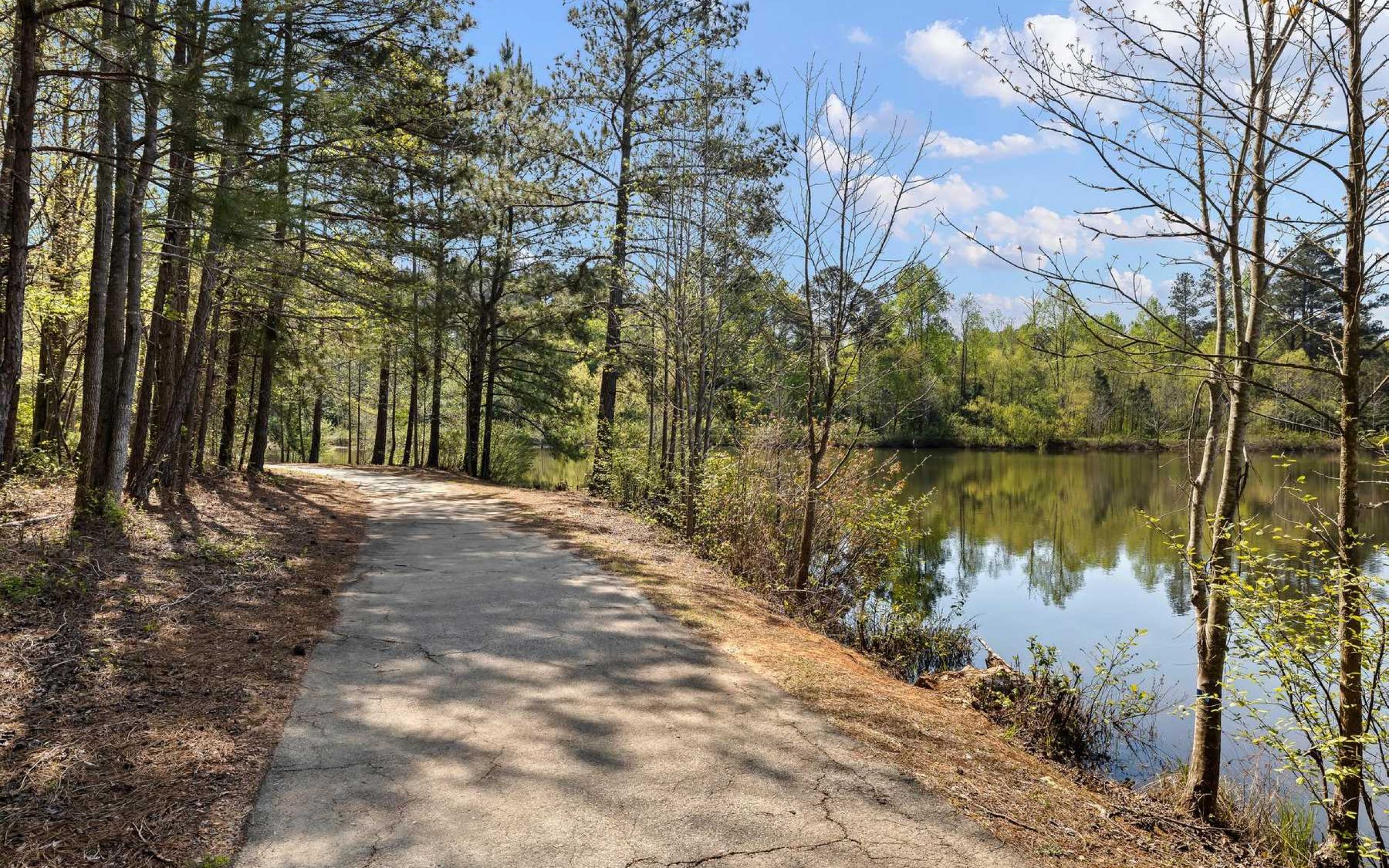 The Claiborne at Baton Rouge nature trails walking path next to lake in Newnan, GA