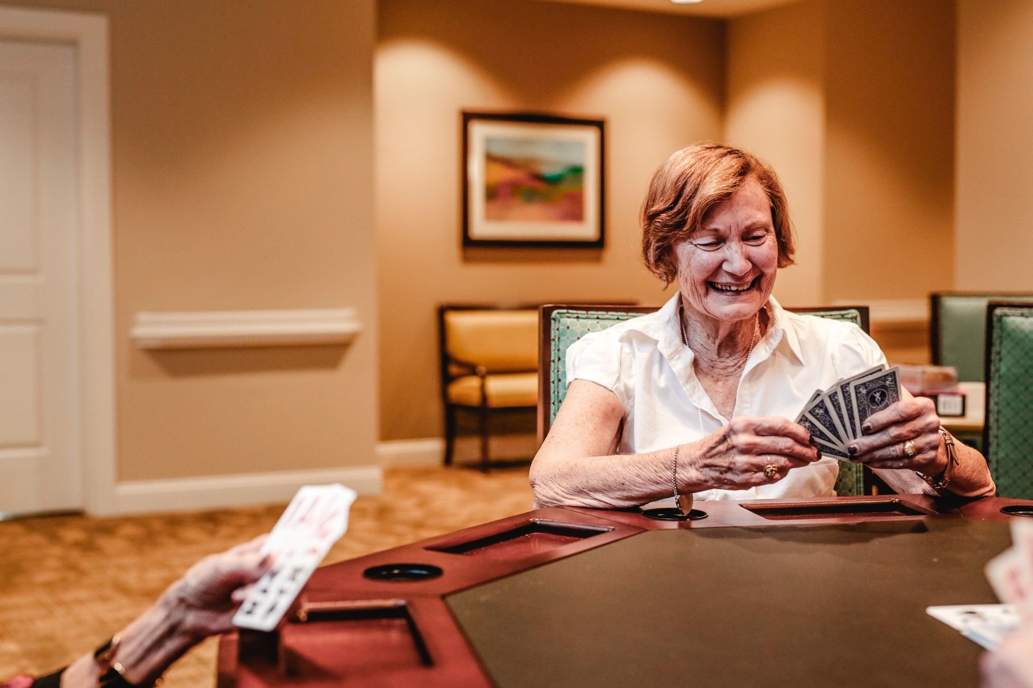 senior living community residents playing cards in the game room