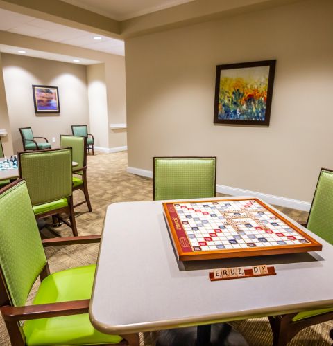 Brickmont at Acworth  resident gaming lounge amenity with tables, lounge chairs, games, and wall art