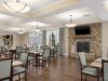 Brickmont at Acworth resident dining room amenity with tables and chairs, a stone fireplace, and grand piano