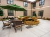 Brickmont at Acworth outdoor patio courtyard with gardens, tables, chairs, and umbrellas