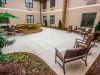 Brickmont at Johns Creek outdoor patio courtyard with gardens, tables, chairs, and umbrellas