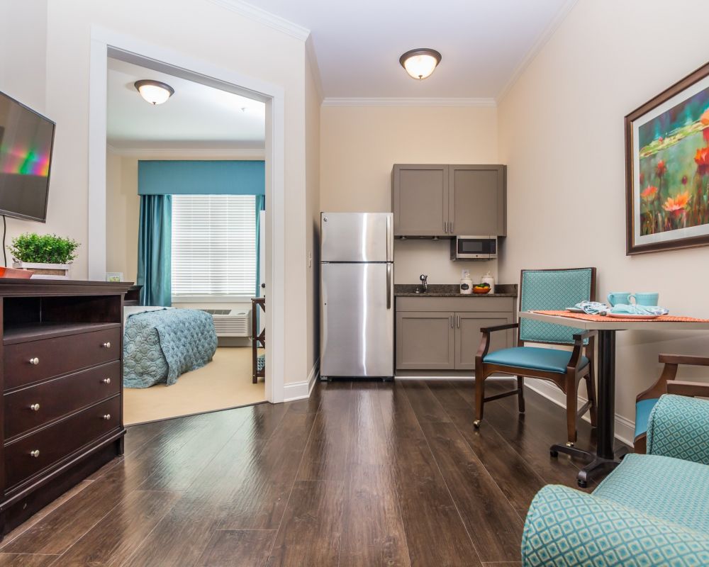 Brickmont at John's Creek senior living community apartment kitchenette, furnished living space, and large bedroom