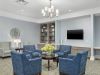 Brickmont at Johns Creek senior living community building elevator seating area with comfy chairs, table, lamp, and wall art