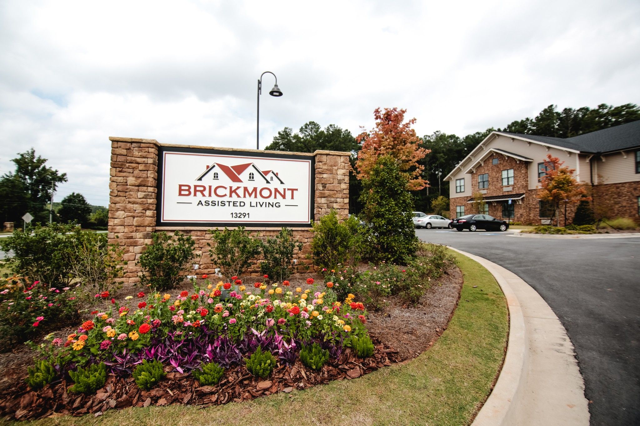 Brickmont at Roswell  assisted living community exterior and parking lot surrounded by forest