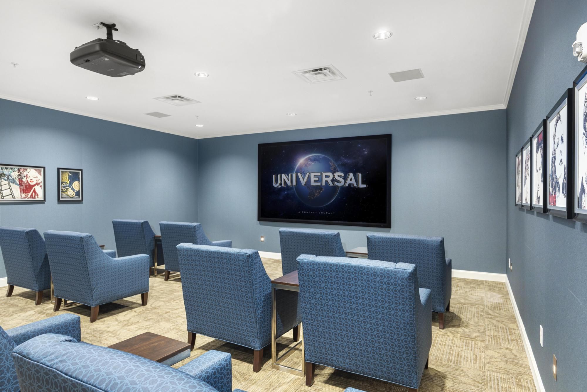 Brickmont at Roswell resident movie theater amenity with lounge chairs and tables, wall art, and a popcorn machine