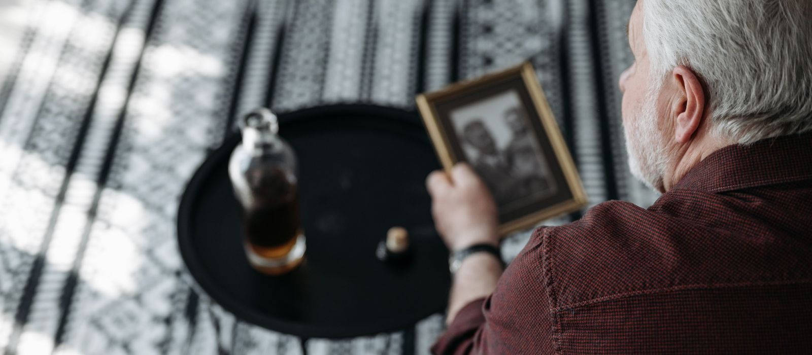 Man looking at a picture frame in a living room