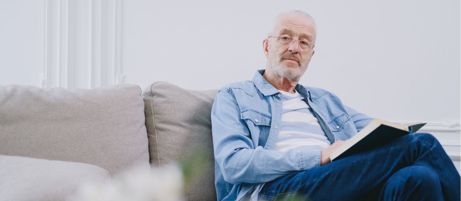 Man sitting on a couch with a book