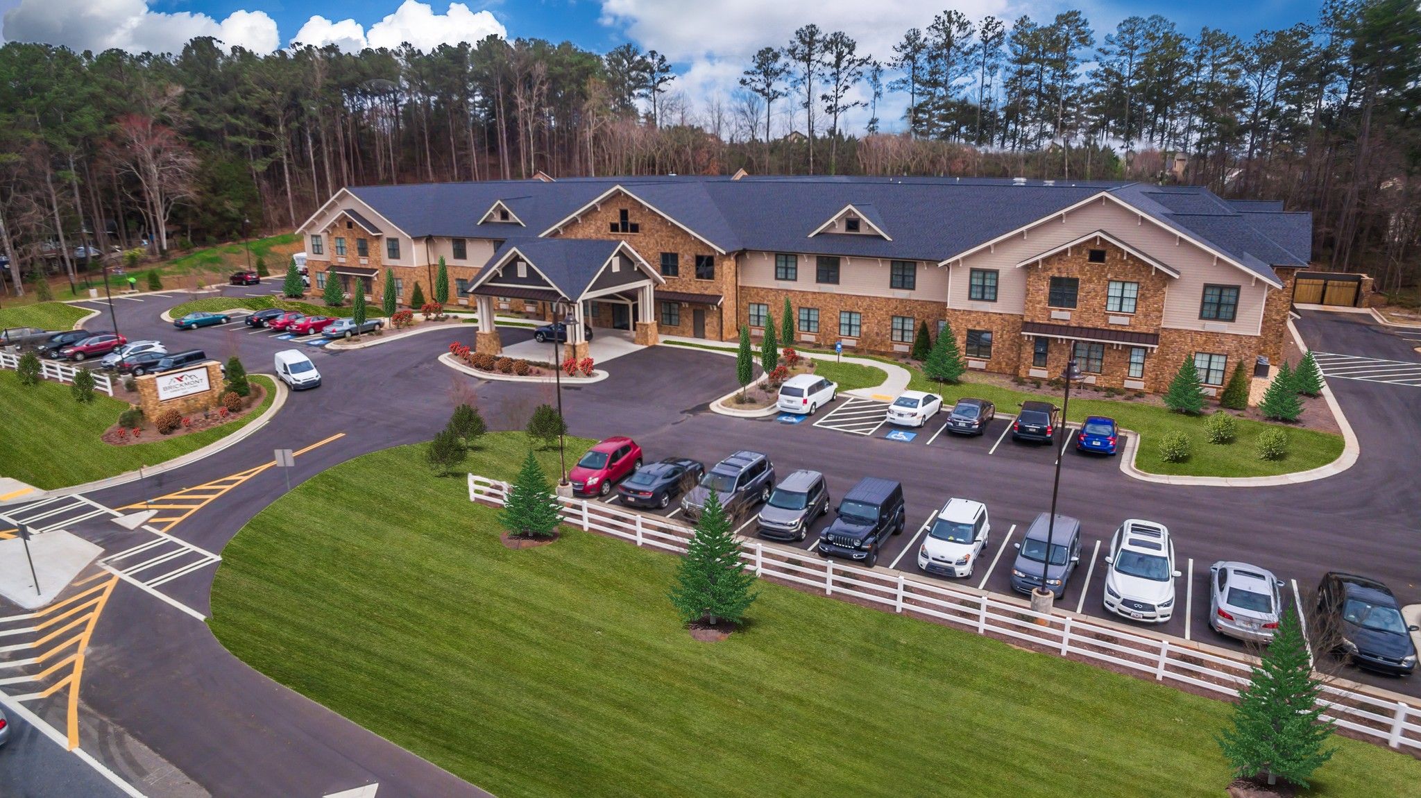 Brickmont at Roswell   assisted living community exterior and parking lot surrounded by forest