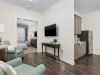 Brickmont at Roswell apartment living room with lounge chairs, cabinet, and mounted flat screen tv