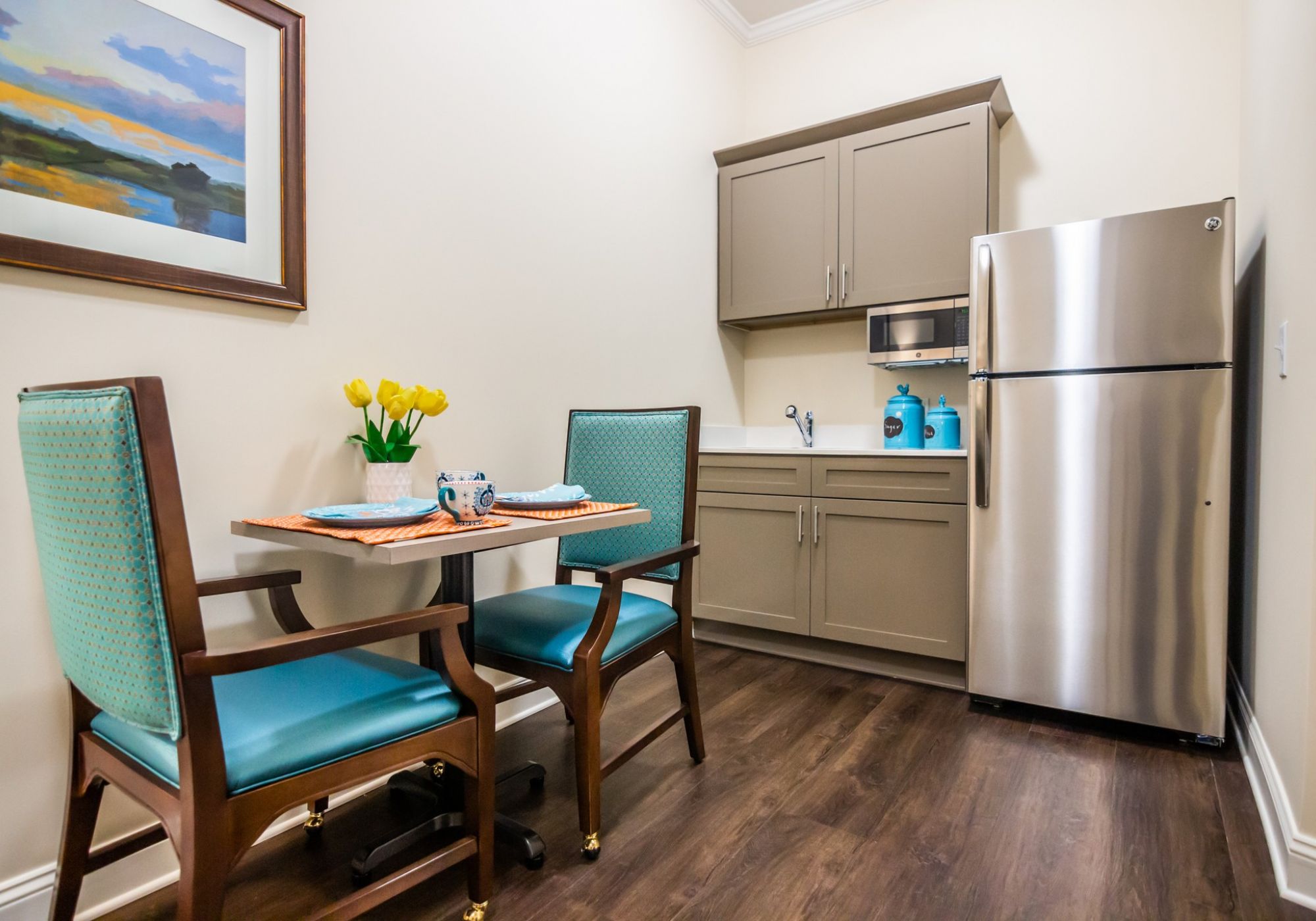 Brickmont at Roswell apartment kitchenette with table and chairs, full sized fridge, and storage