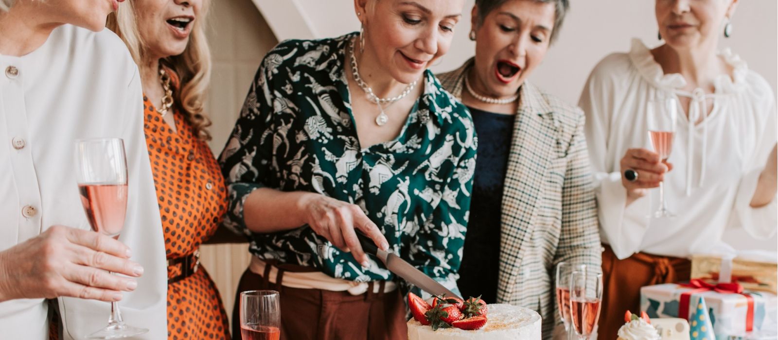 Women cutting a cake at a birthday party