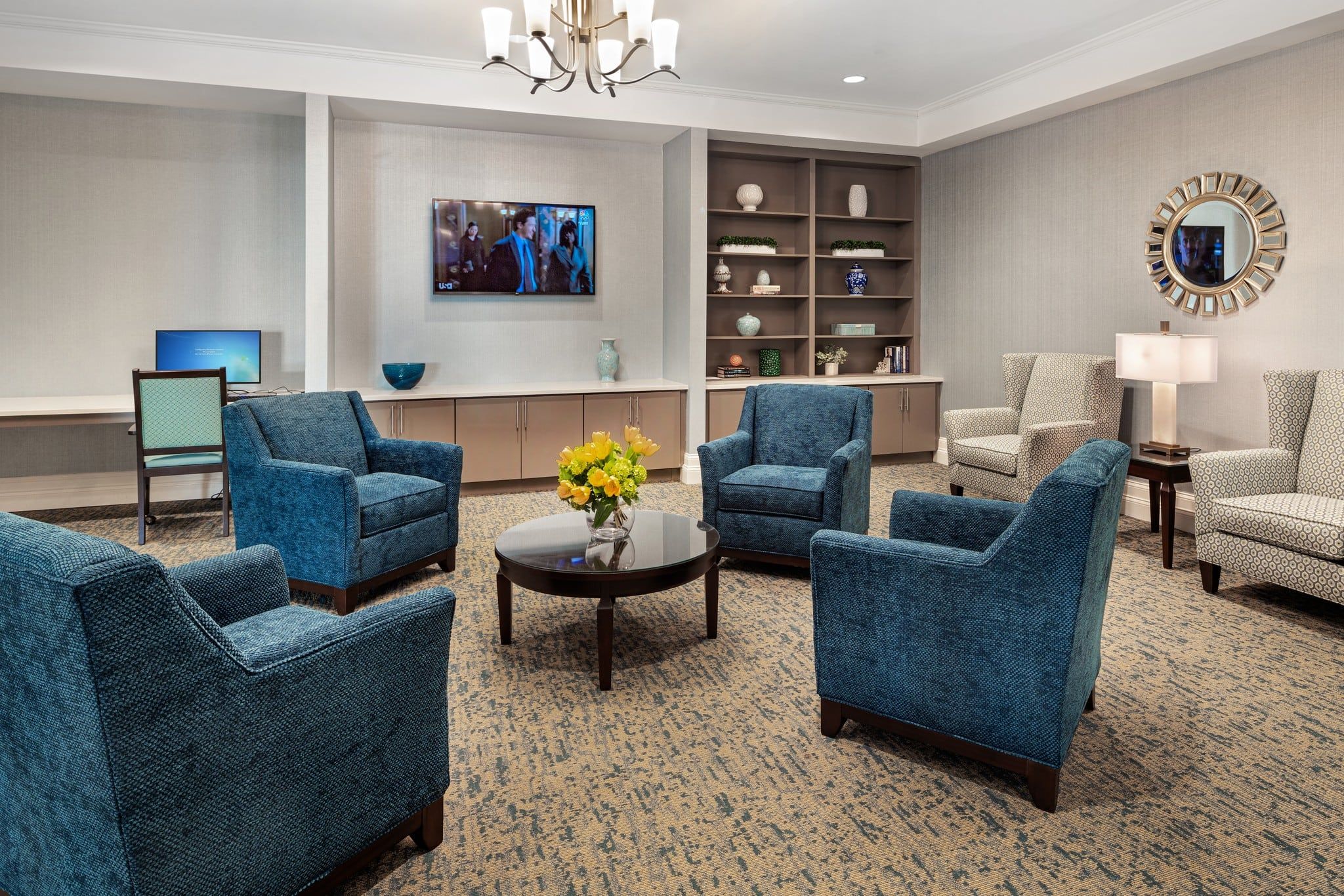 Brickmont at West Cobb common sitting area with lounge chairs, tvs, bookshelves, and a computer station