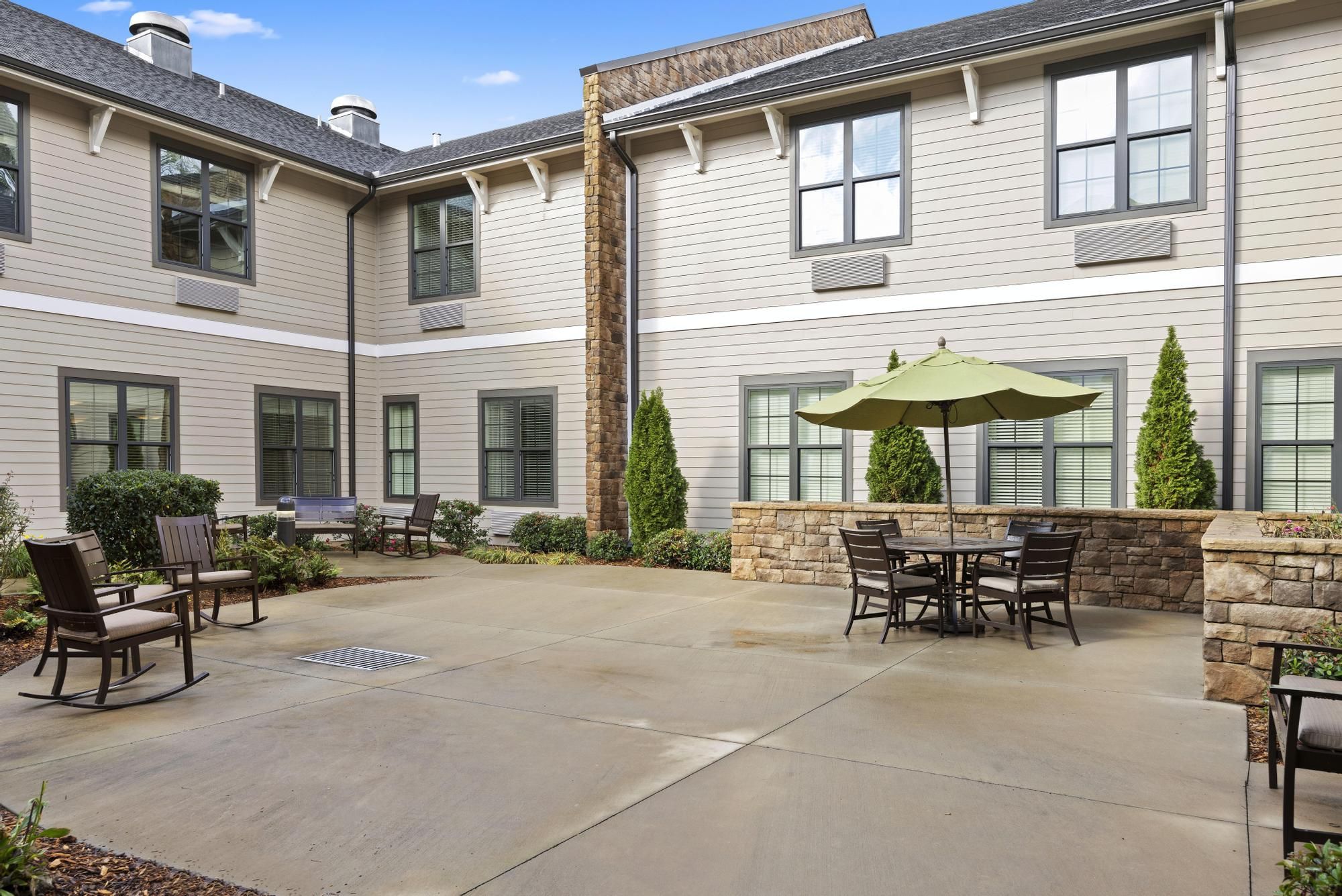 Brickmont at West Cobb outdoor patio courtyard with gardens, tables, chairs, and umbrellas
