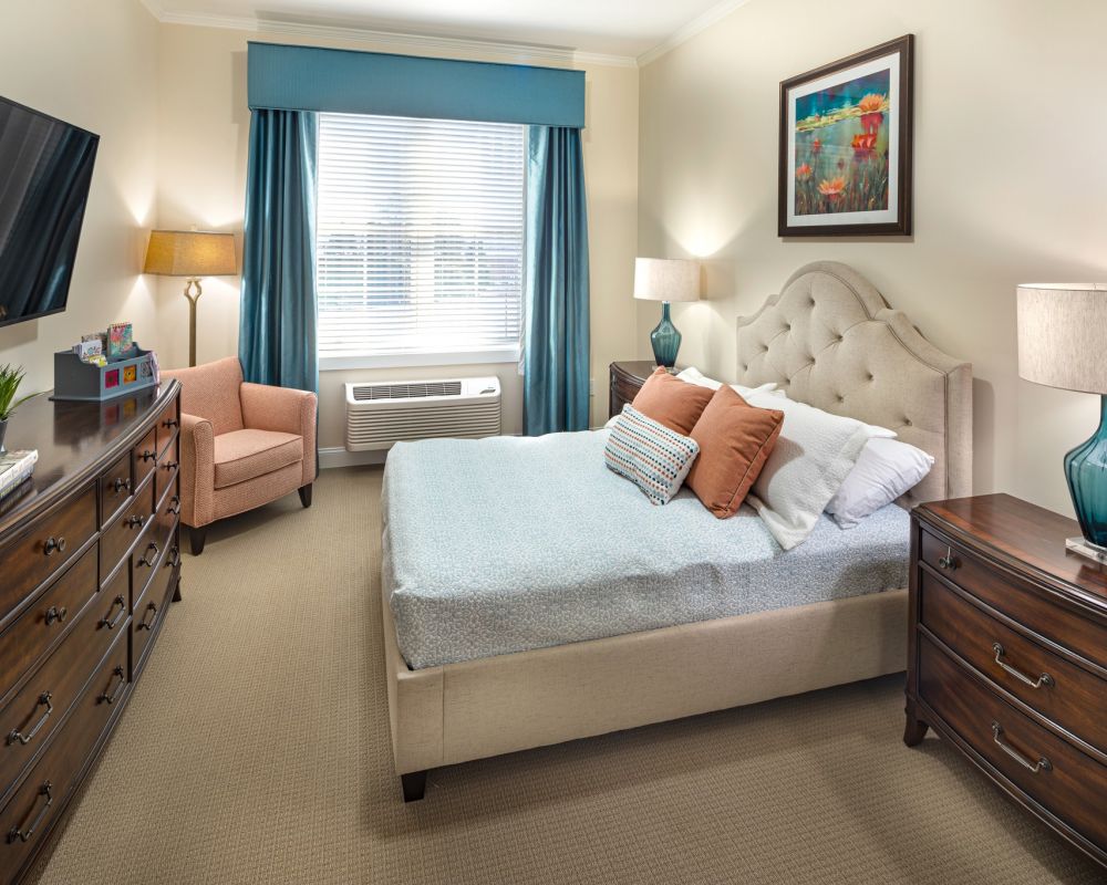 apartment bedroom with full sized bed, carpeting, and sliding barn doors to main living space