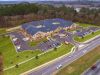 Brickmont at West Cobb aerial view of assisted living community exterior and parking lot surrounded by forest