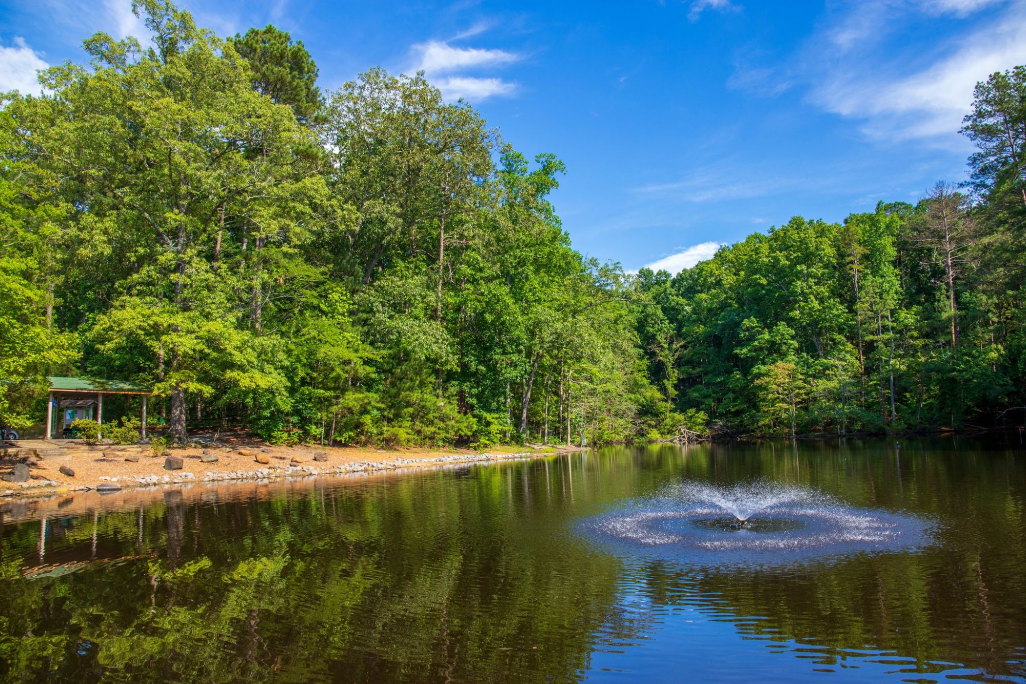 Brickmont at Woodstock summer landscape of a lake, fountain, and forest in Dupree Park in Woodstock, GA