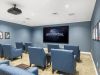 Brickmont at Woodstock resident lounge amenity with lounge chairs, a water feature, decorative bookshelves, and a flat screen tv