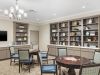 Brickmont at Woodstock resident dining room amenity with tables and chairs, a stone fireplace, and flat screen tv