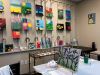 Camellia Place Art studio with colorful paintings on the wall and easels displaying lavender flower paintings on tables.