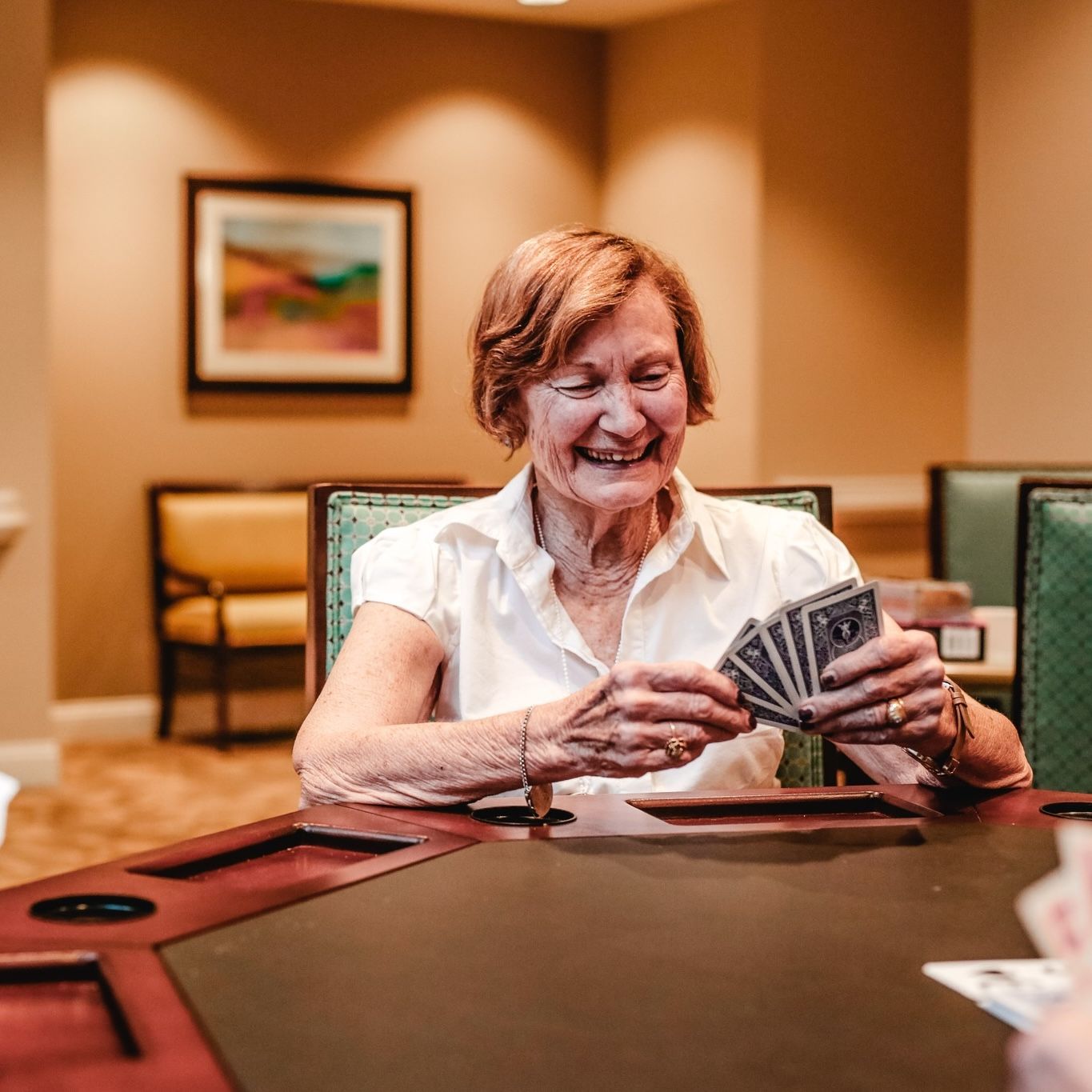 The Claiborne at Acworth senior living community residents playing cards in the game room