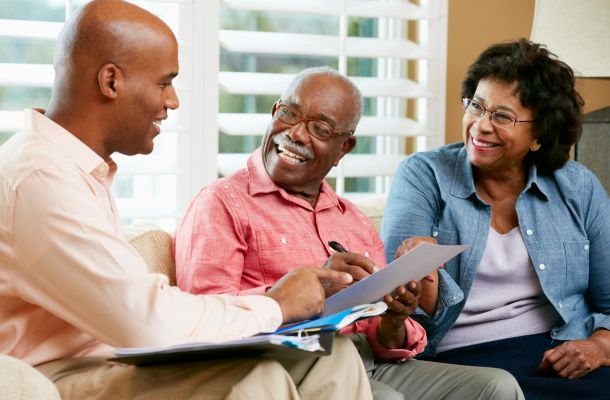 A financial advisor meets with an older couple to review documents.