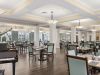 The Claiborne at Acworth resident dining room amenity with tables and chairs, a stone fireplace, and grand piano