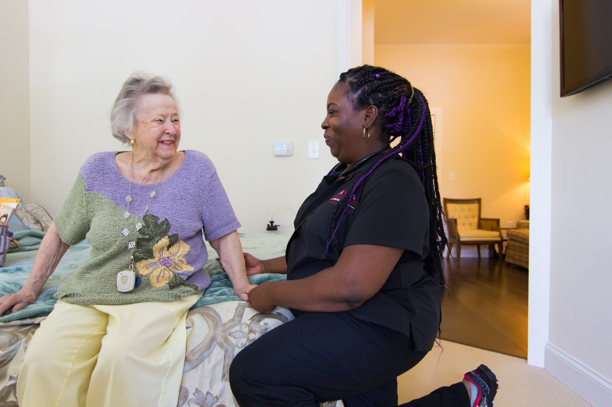 The Claiborne at Johns Creek senior living community staff member assisting a resident in her apartment