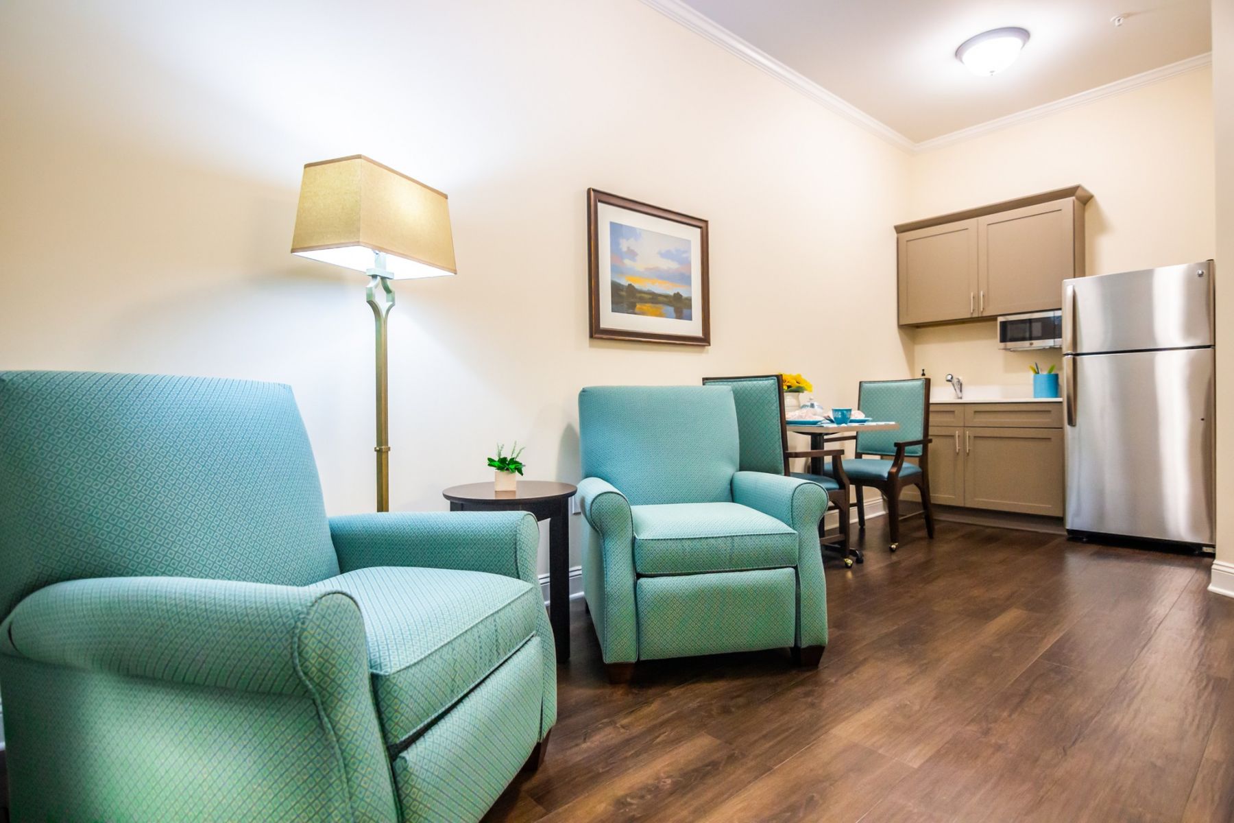  upscale apartment kitchenette with quartz countertops, stainless steel appliances, and sitting areaThe Claiborne at Johns Creek