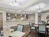The Claiborne at Johns Creek resident dining room amenity with tables and chairs, a stone fireplace, and grand piano