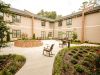 The Claiborne at Roswell outdoor patio courtyard with gardens, tables, chairs, and umbrellas
