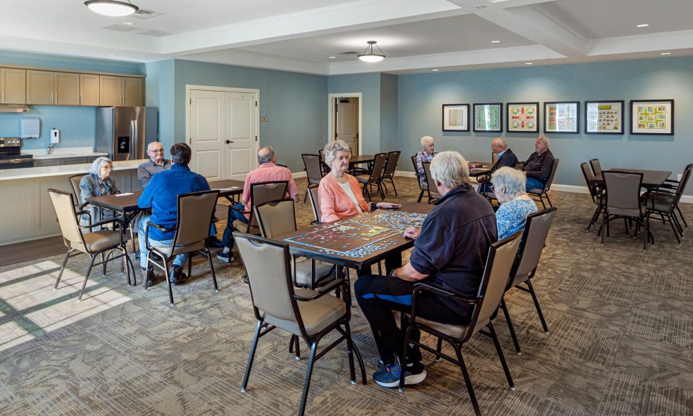 The Claiborne at West Cobbresident gaming lounge amenity with full kitchen, tables, chairs, games, and wall art