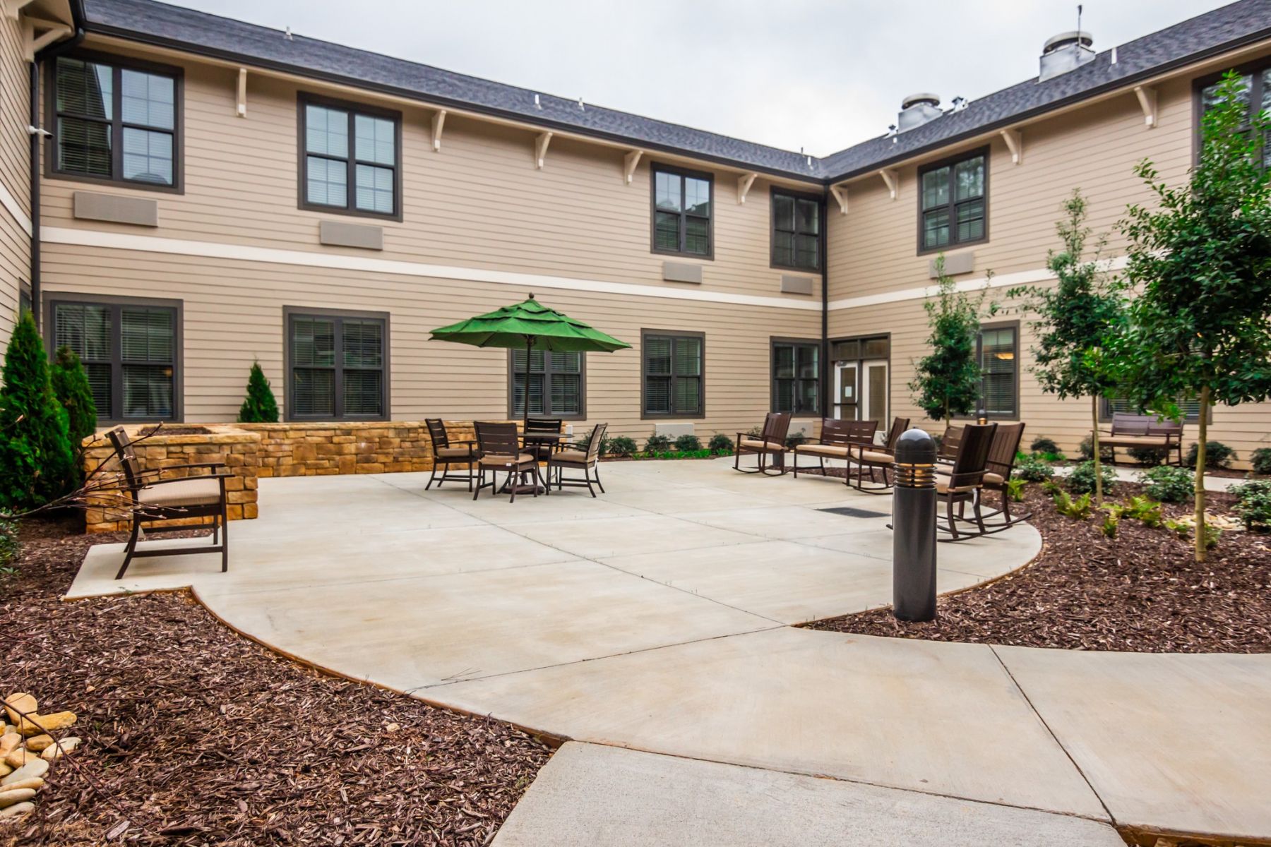 The Claiborne at West Cobb outdoor patio courtyard with gardens, tables, chairs, and umbrellas