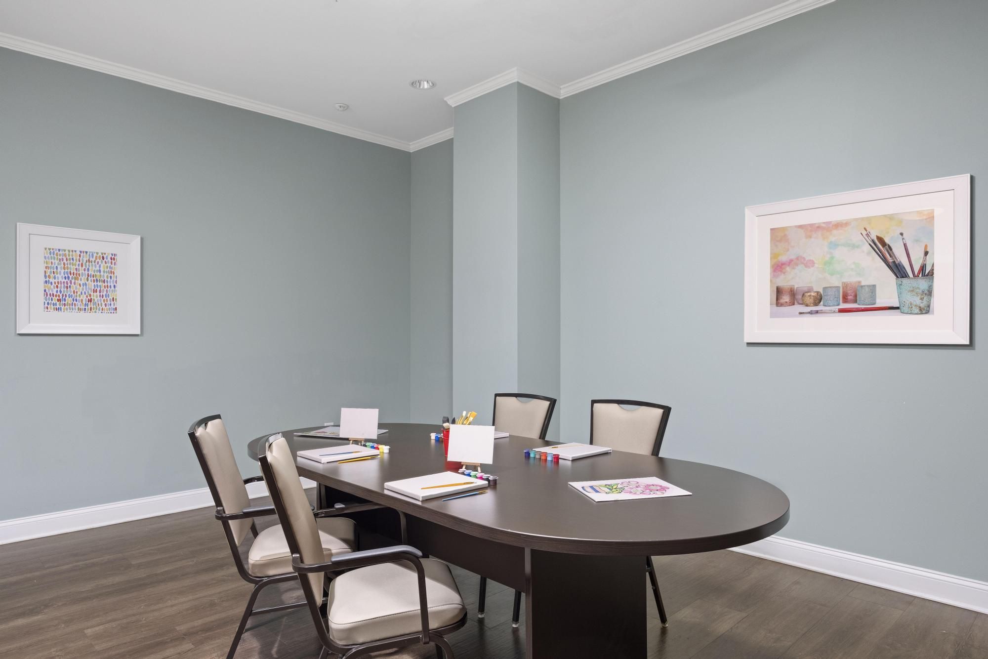 The Claiborne at West Cobb resident gaming lounge amenity with full kitchen, tables, chairs, games, and wall art