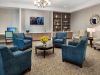 The Claiborne at West Cobb common sitting area with lounge chairs, tvs, bookshelves, and a computer station