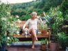 The Claiborne at West Cobbwoman drinking coffee sitting on bench with dog