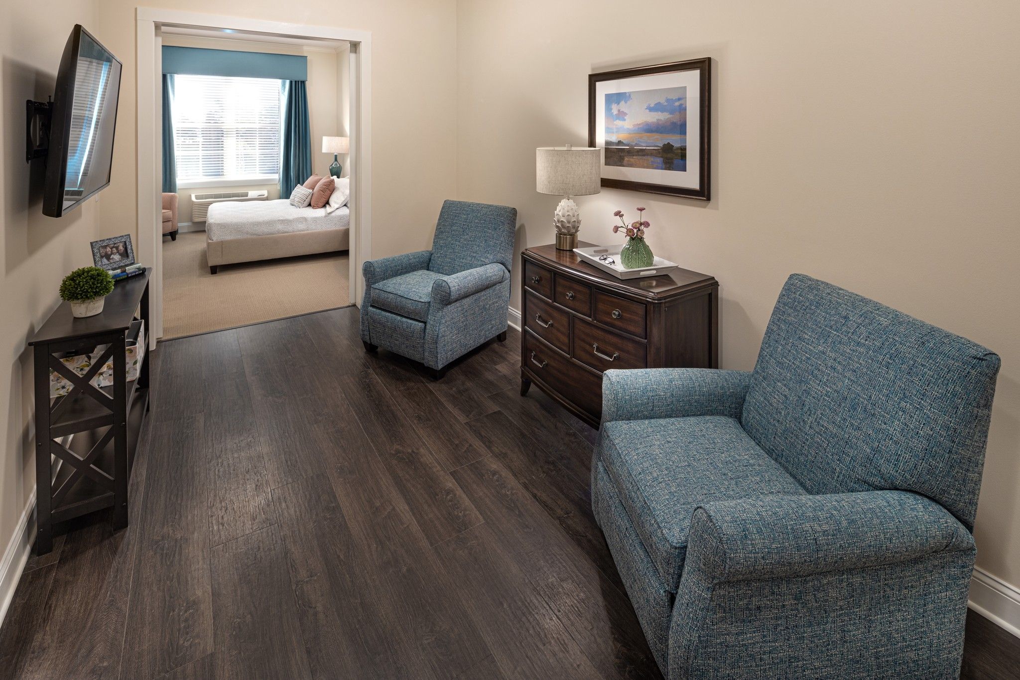 The Claiborne at West Cobb apartment living room with lounge chairs, cabinet, and mounted flat screen tv