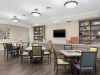 The Claiborne at Woodstock resident gaming lounge amenity with tables, lounge chairs, games, and wall art