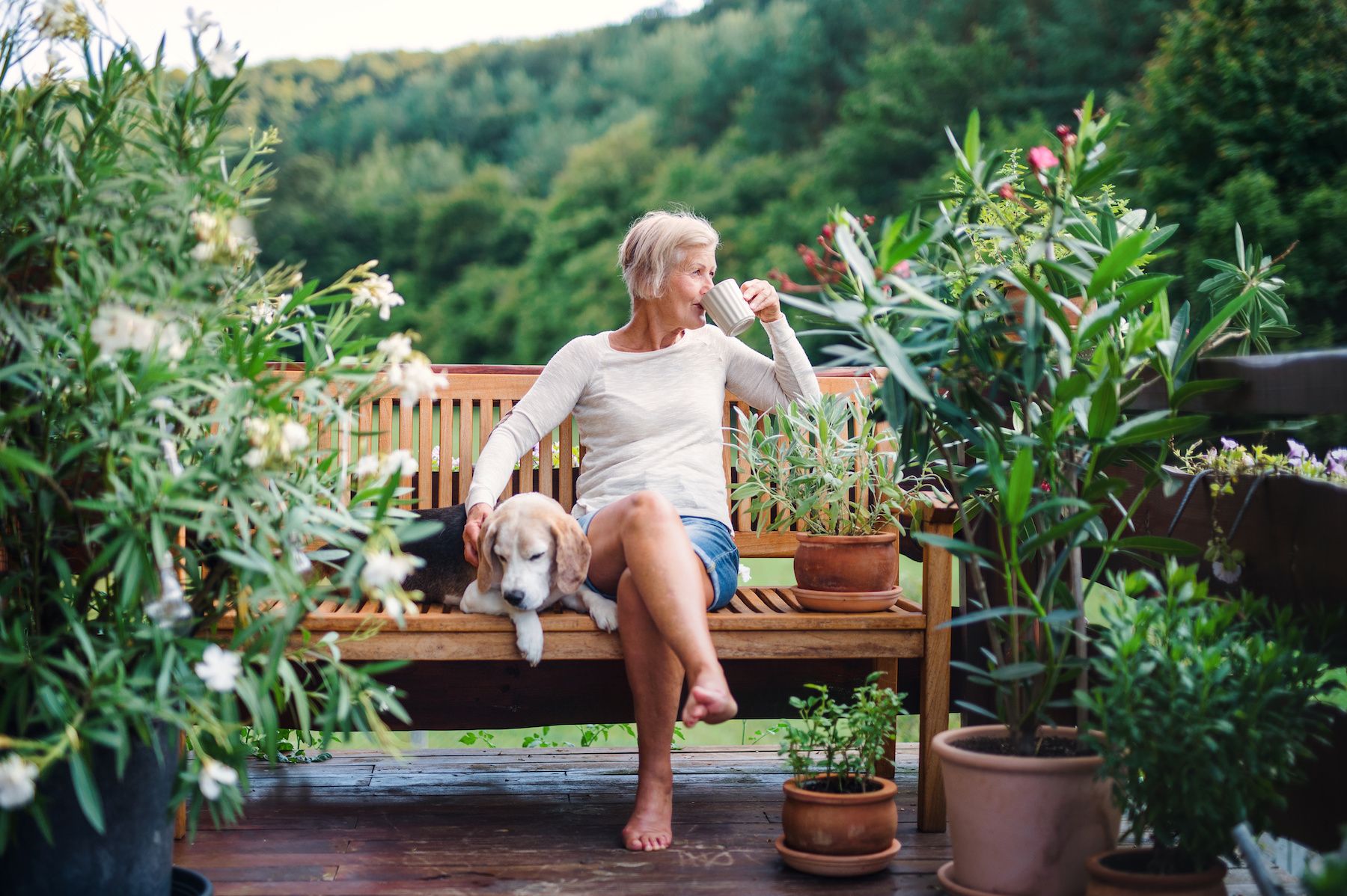 The Claiborne at Woodstockwoman drinking coffee sitting on bench with dog
