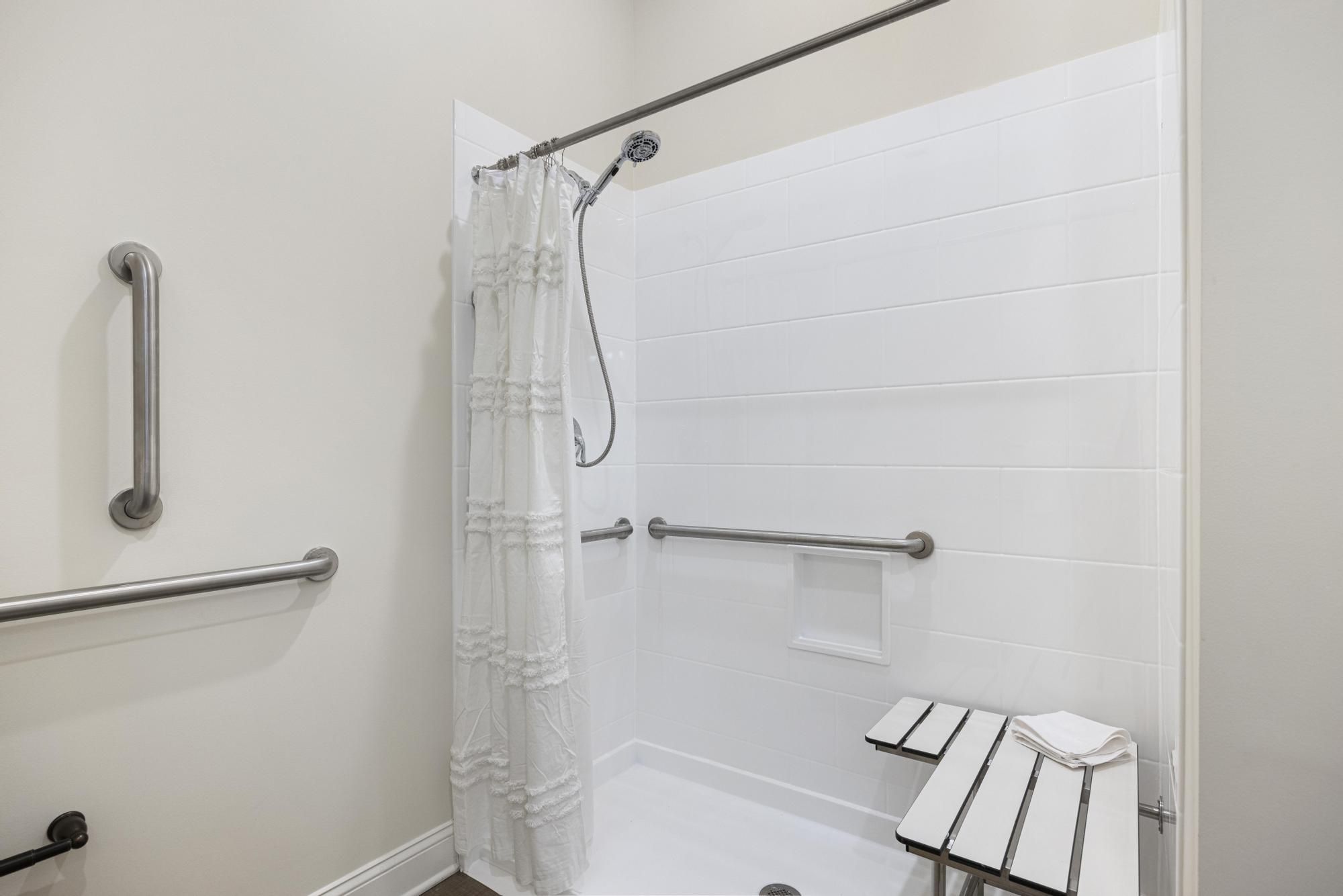 The Claiborne at Woodstock apartment bathroom with walk-in shower, accessible sink, and ample storage