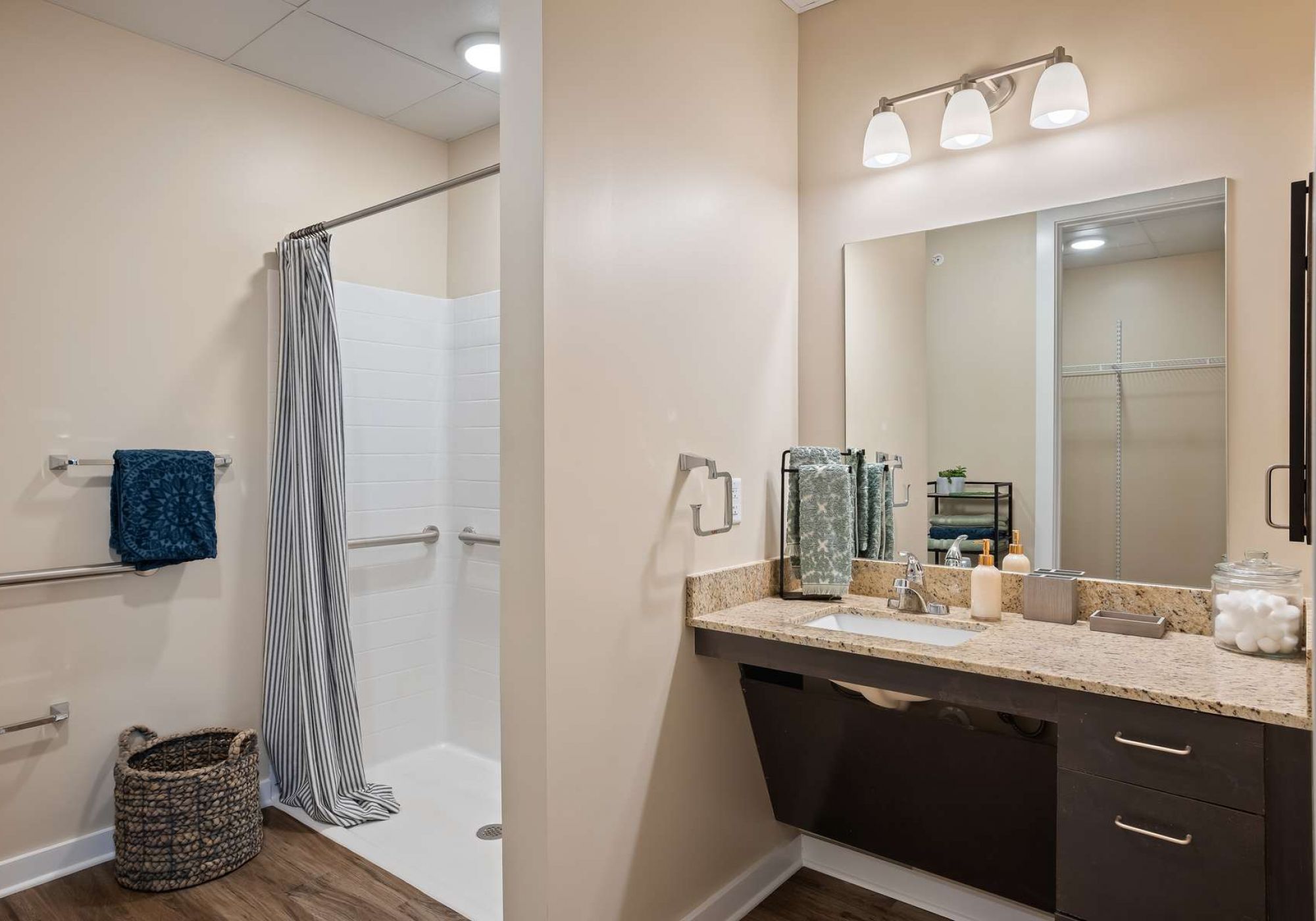 The Claiborne at Gulfport Highlands senior living community bathroom showing accessibility features including handrails, lower sink height, and zero-entry shower