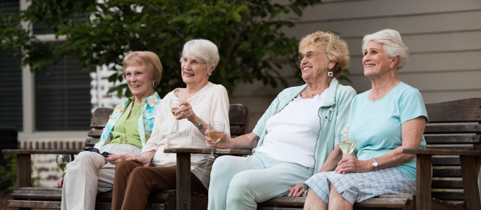 senior women relaxing and talking outside on a bench