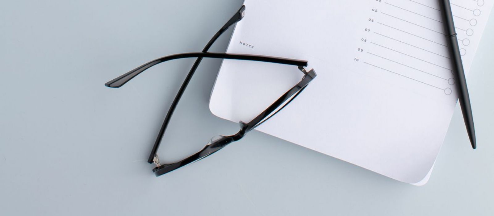 Coffee, glasses, and to-do list resting on a table.