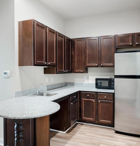 The Claiborne at Hattiesburg senior apartment full kitchen with stainless steel appliances and high-end finishes