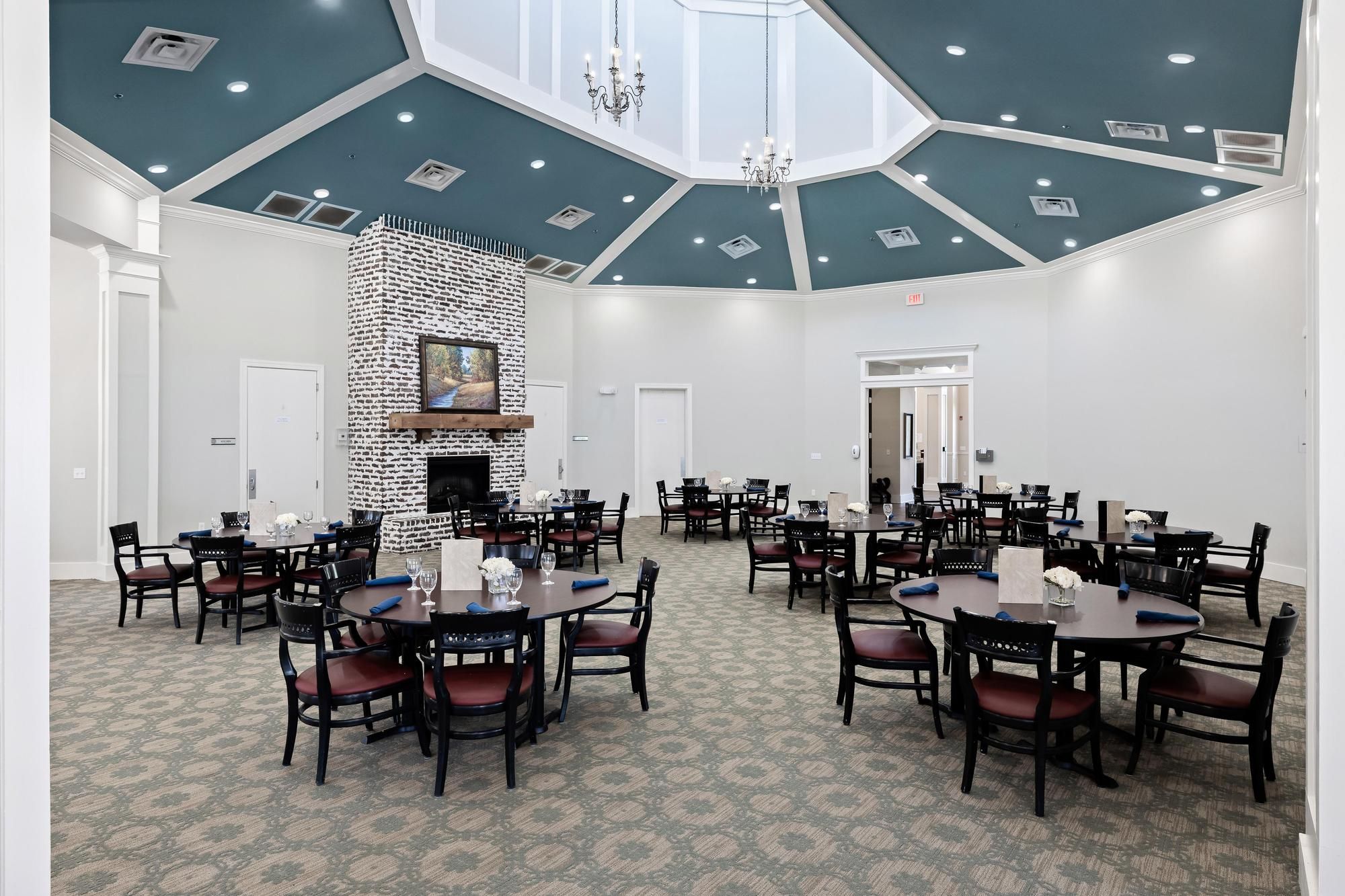 The Claiborne at Hattiesburg independent living dining area with chandeliers and seating