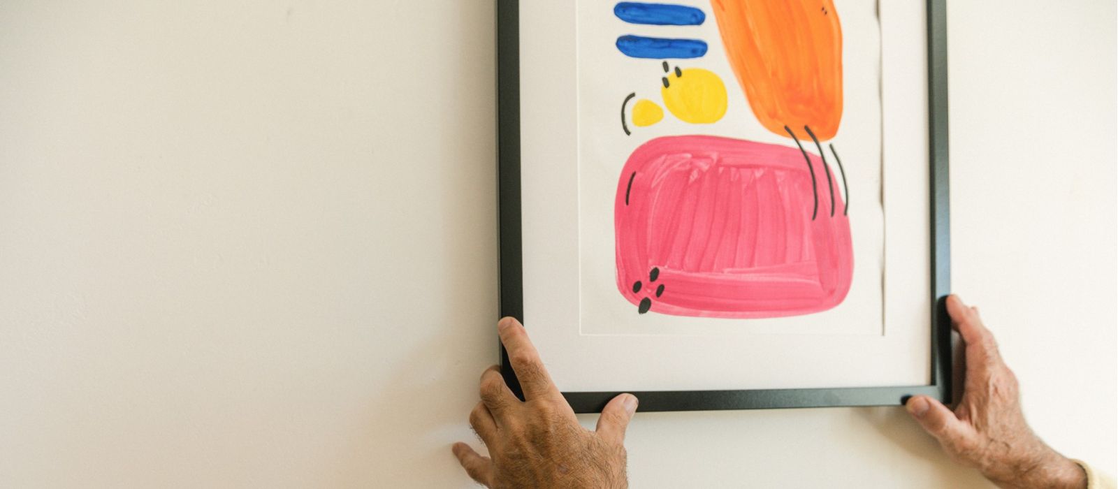 Man hanging a photo on a wall