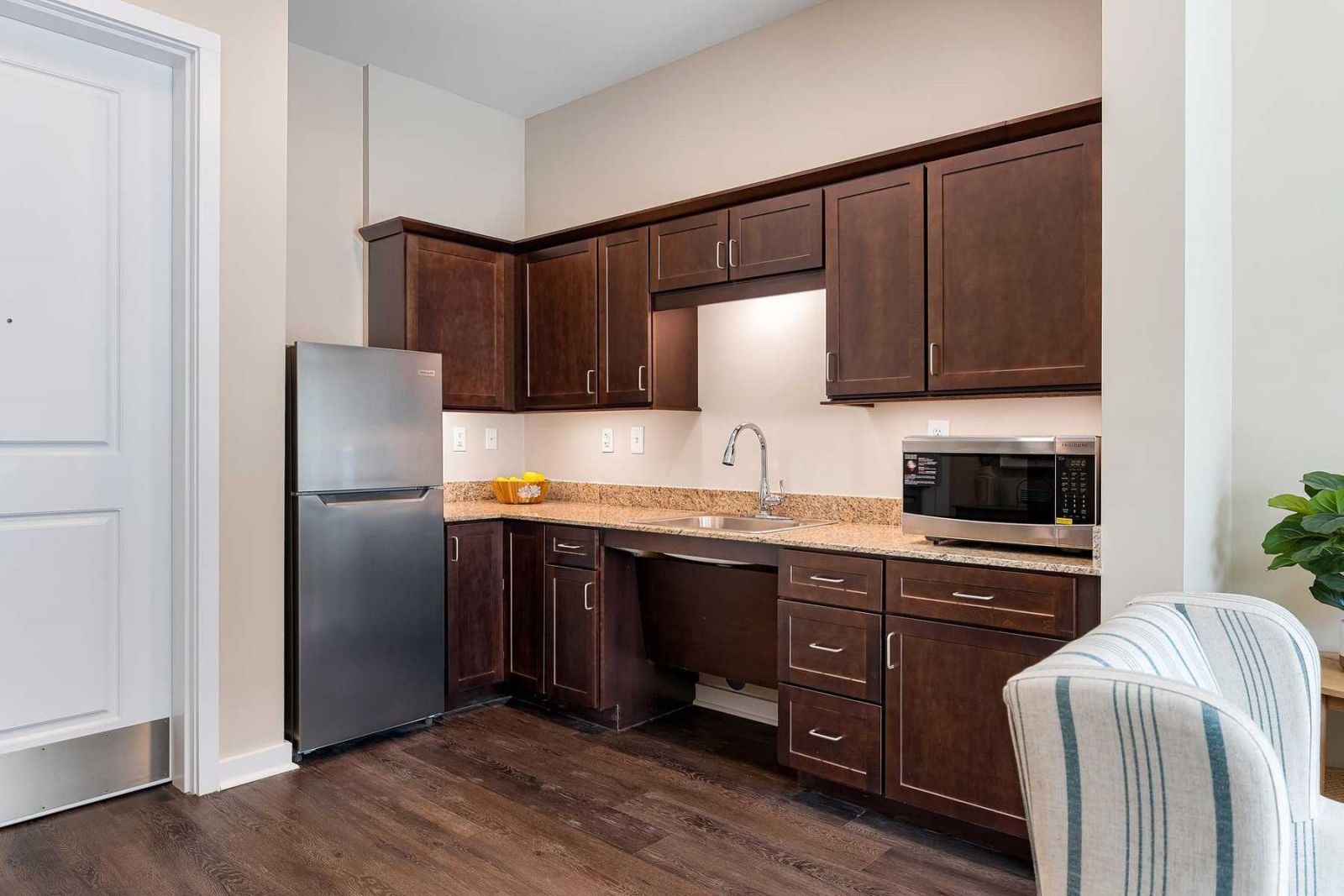 The Claiborne at Newnan Lakes assisted living kitchenette showing accessibility features including sink and cabinet height