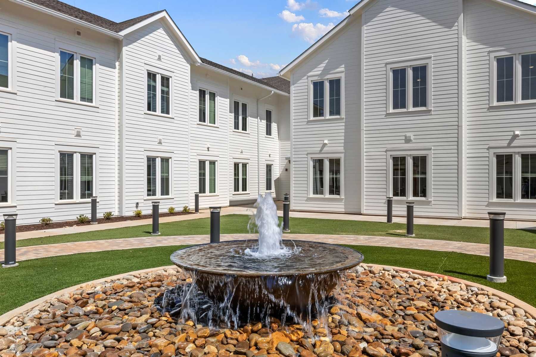 The Claiborne at Newnan Lakes outdoor courtyard with fountain and walking paths